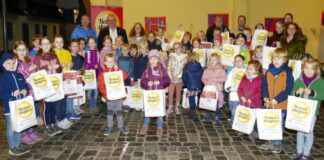 Bürgermeister Klaus Schindling, Mitglieder des Gewerbevereins Hattersheim sowie die städtische Wirtschaftsförderung hatten den teilnehmenden Kindern der Heimatshoppen-Rallye als Dankeschön und Motivation zum Mitmachen im nächsten Jahr Überraschungstüten überreicht. (Foto: Hans Nietner)