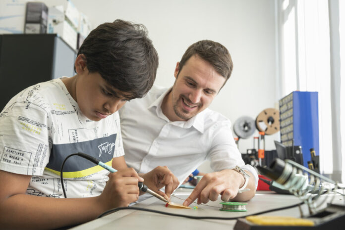 Das Foto anbei zeigt Ralf Schlosser, Leiter des DLR_School_Lab TU Darmstadt, mit einem Schüler beim Löten. (Foto: Klaus Mai / IHK Darmstadt)