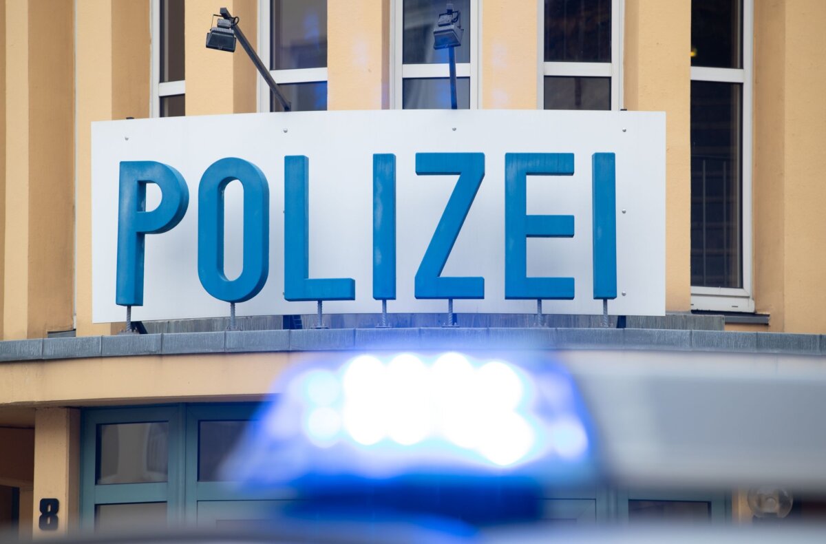 Ein Einsatzwagen der Polizei steht vor einer Dienststelle.