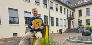 Lukas Reinelt vom städtischen Umweltamt mit Ausgaben des „Griesheimer Hitzeknigge“ vor dem Rathaus. Foto: Stadt Griesheim