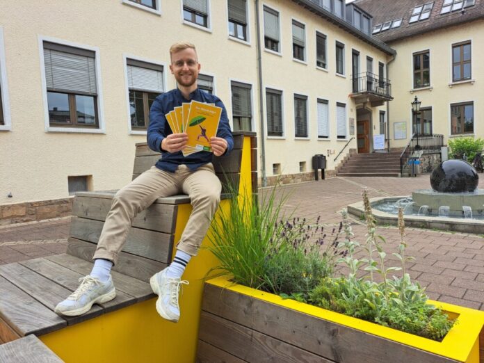 Lukas Reinelt vom städtischen Umweltamt mit Ausgaben des „Griesheimer Hitzeknigge“ vor dem Rathaus. Foto: Stadt Griesheim